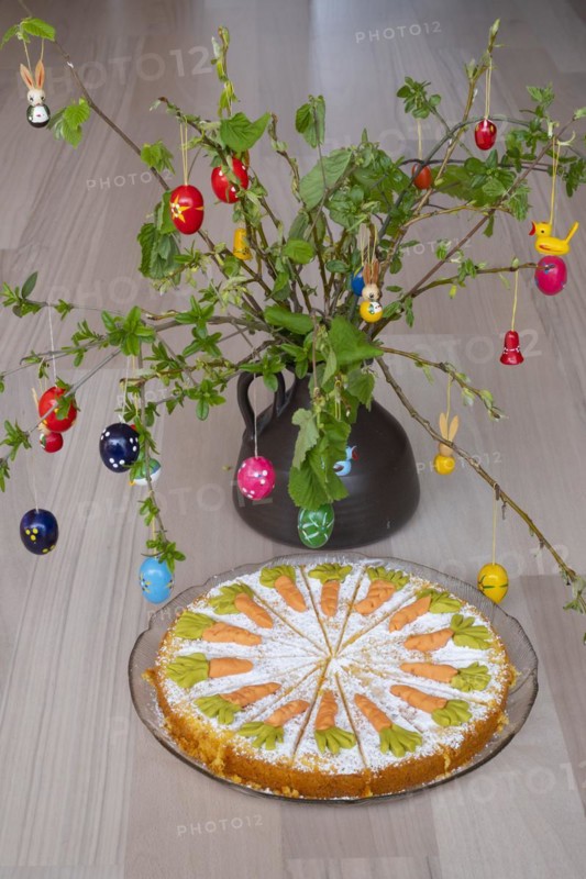 Homemade carrot cake in front of a shrub with Easter decorations