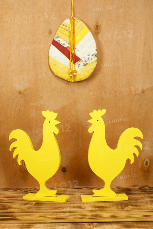 Two yellow wooden rooster figures