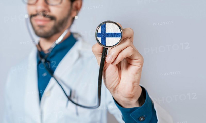 Doctor holding stethoscope with Finland flag. Finland Health and Care Concept