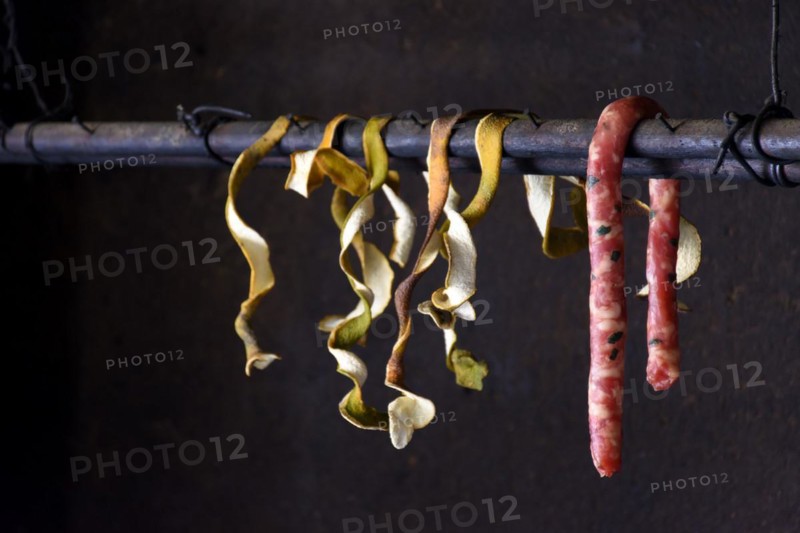 Raw sausage and orange coats hanging in the interior of popular cuisine in Brazil