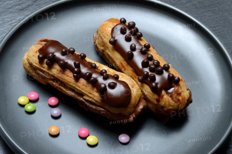 Two chocolate eclairs on a plate