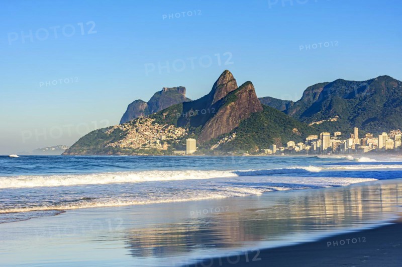 Dawn in the city of Rio de Janeiro with the empty Ipanema beach with the reflection of the buildings in the wet sand