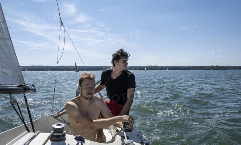Two young men sailing on a sailboat