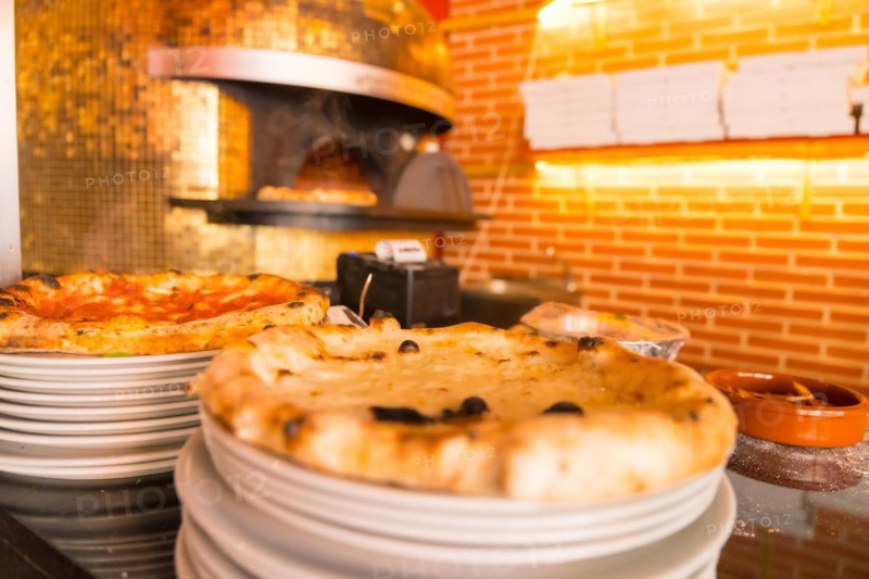 Artisan pizza oven. Freshly made pizza coming out of the oven