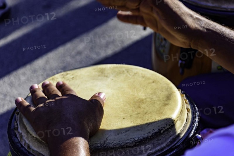 Drum player playing atabaque during presentation of afro music on the eve of the Brazilian carnival