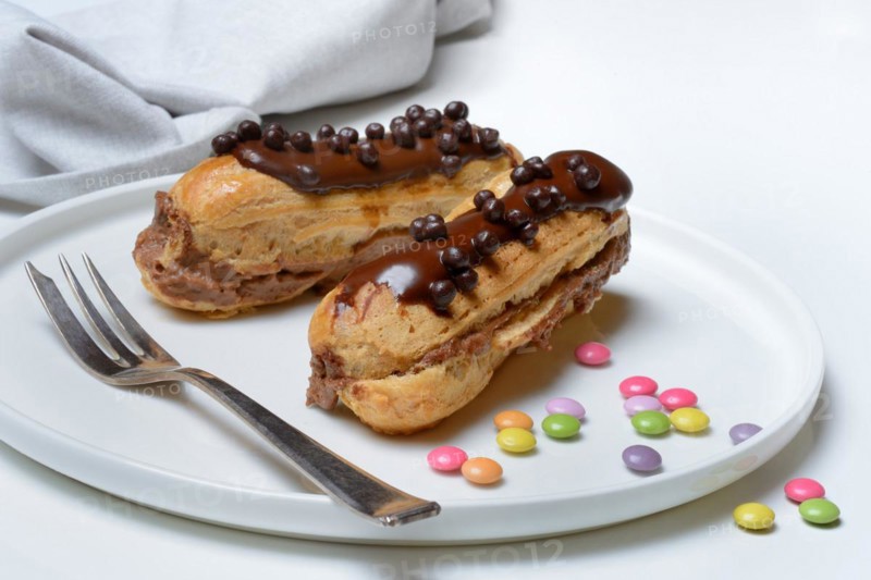 Two chocolate eclairs on a plate