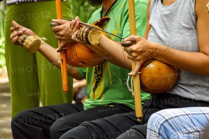 Musicians playing Afro Brazilian percussion musical instruments called berimbau during a capoeira performance in the streets of Brazil