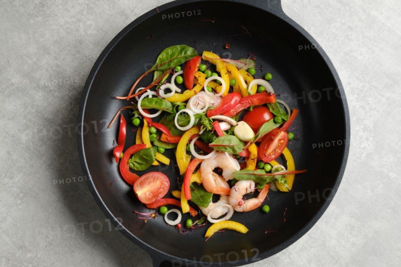 Top view of fresh vegetables and shrimps in a frying pan