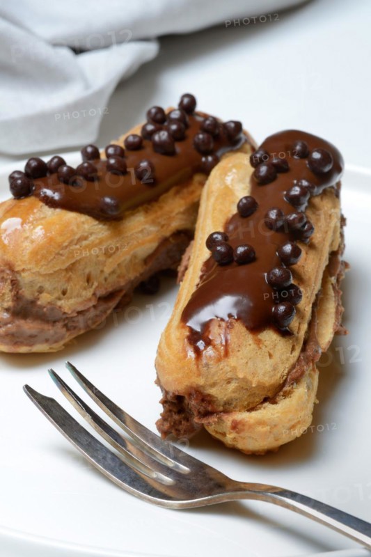 Two chocolate eclairs on a plate