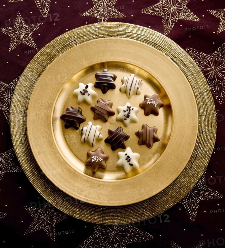 Chocolates as Christmas stars on a golden plate
