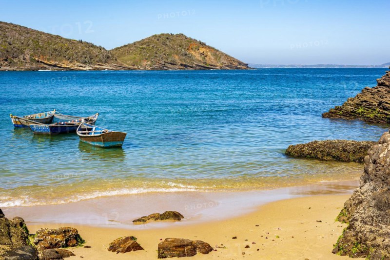 Old wooden fishing boat floating on the colorful and transparent waters of the sea of Buzios in the state of Rio de Janeiro