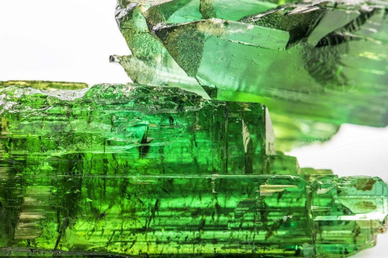 Two brazilian green tourmaline raw crystal with white background