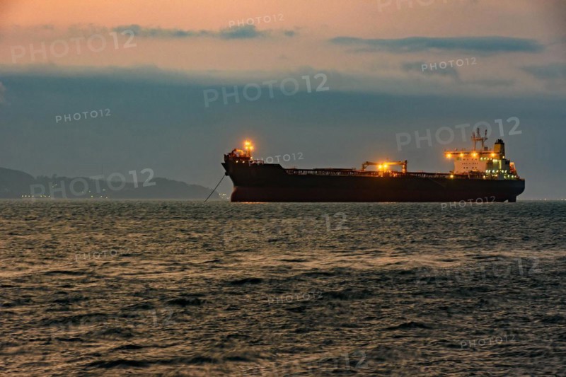 Cargo ship anchored in the waters of Ilhabela Island at dusk with the mountains in the background