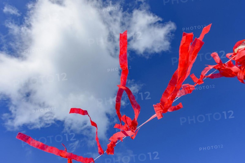Decorative vivid red ribbons prepared for a religious festival in the city of Lavras Novas in Minas Gerais swaying in the wind with blue sky