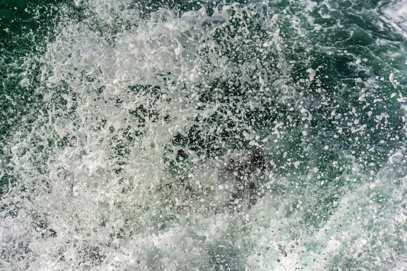 Texture of drops of sea water splashing into the air when waves crash against rocks