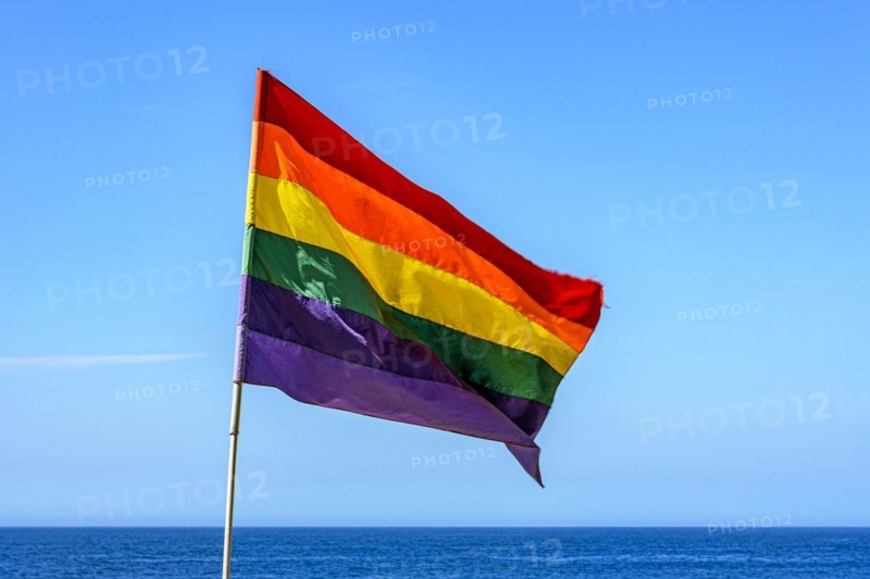 Lbgtq+ flag in the blue sky of the city of Rio de Janeiro