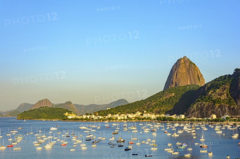 Guanabara Bay with boats floating on the water and the Sugarloaf Mountain in the background during the summer afternoon