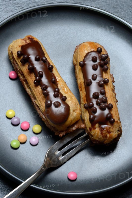 Two chocolate eclairs on a plate