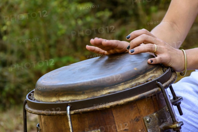 Woman percussionist hands playing a drum called atabaque during brazilian folk music performance