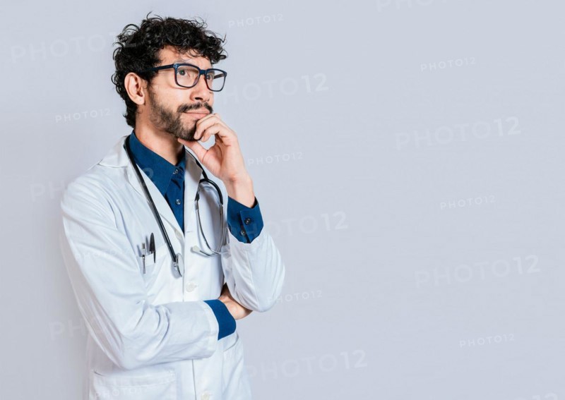 Young doctor thinking and looking up isolated. Pensive doctor man looking up isolated