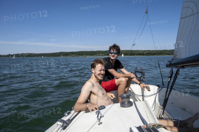 Two young men sailing on a sailboat