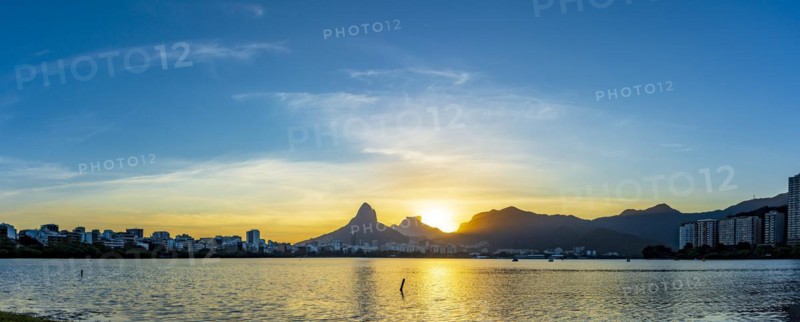 Panoramic photograph of Rodrifgo de Freitas lagoon during sunset with its waters and hills in the neighborhoods of Ipanema and Leblon