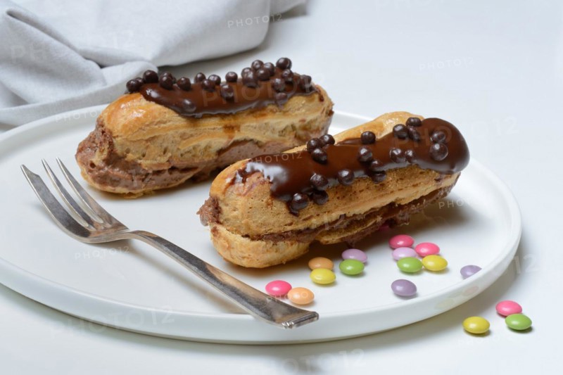 Two chocolate eclairs on a plate
