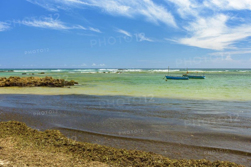 Fishing boats on the colorful waters of Itapua beach in Salvador