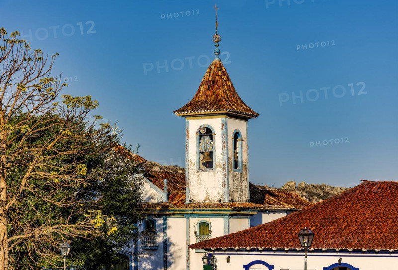 Baroque church bell tower with rising through the trees and roofs of the historic town of Diamantina in Minas Gerais