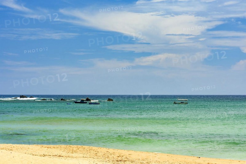 Wooden fishing boats on the colorful waters of Itapua beach in Salvador