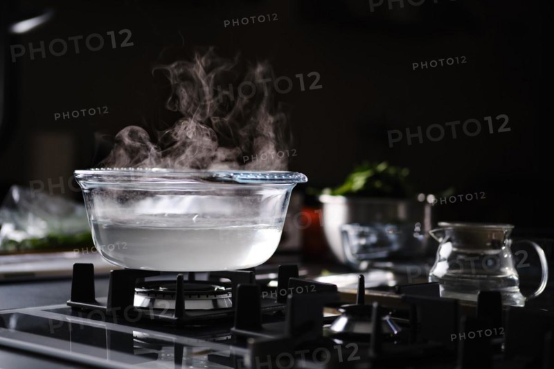 Hot water in transparent pot on gas stove