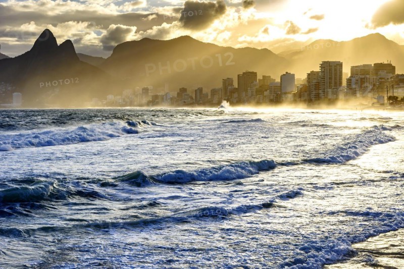 Summer sunset with cloudy sky with Two Brothers hill and Vidigal slum view from Ipanema beach at Rio de Janeiro
