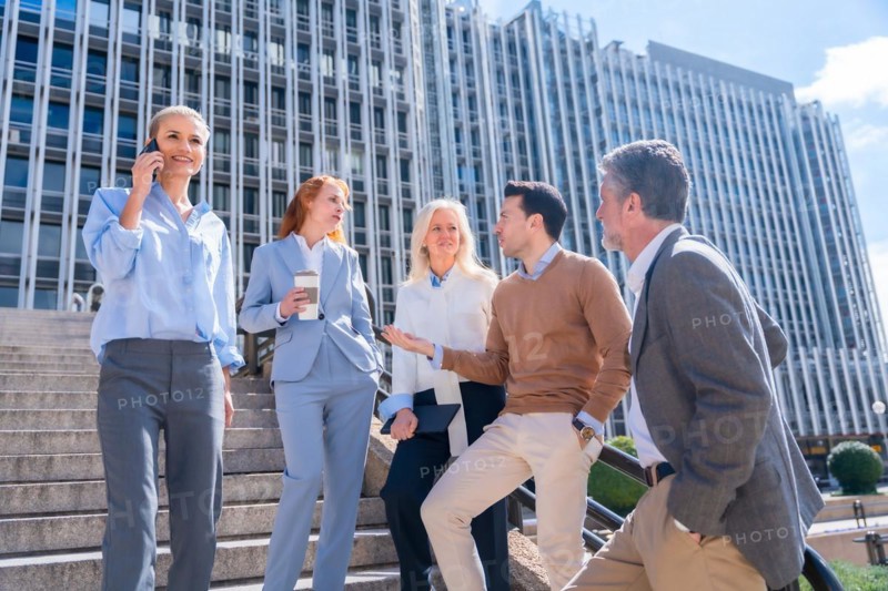 Speaking in a relaxed moment at halftime. Group of coworkers outdoors in a corporate office area