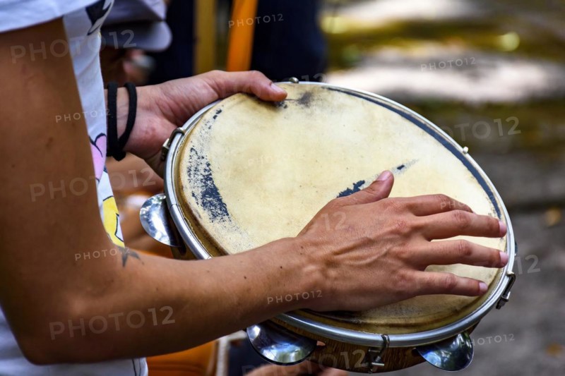 Detail of musician playing tambourine during a samba performance at carnival in the streets of Brazil