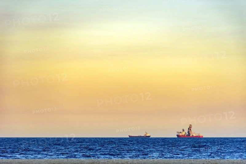 Ships on the horizon during tropical sunset at Copacabana beach in Rio de Janeiro