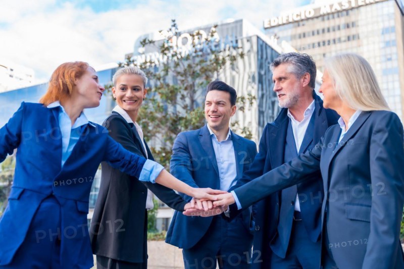 Diverse Group of Senior Executives Celebrate Success with High-Five Gesture