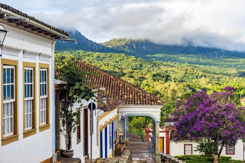 Historic colonial houses with the mountain and forest vegetation lit by the sun in the city of Tiradentes in Minas Gerais