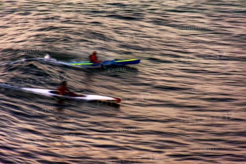 Canoeing at sunset in the sea of the city of Salvador in Bahia with blurred motion and unrecognizable people