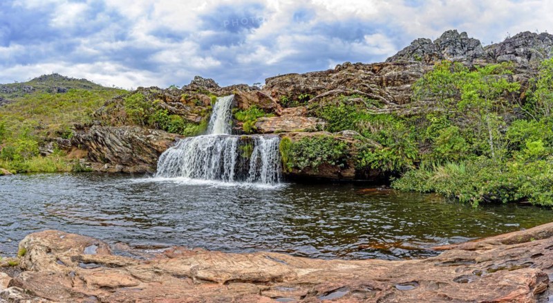 Cascade and lake with mountains in background on Biribiri environmental reserve on Diamantina
