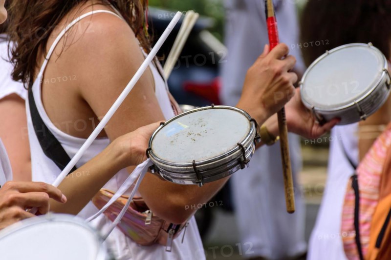 Woman playing tambourine in crowded brazilian streets during carnival festivities
