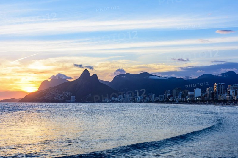 Sunset behind the mountains of the city of Rio de Janeiro on Ipanema beach