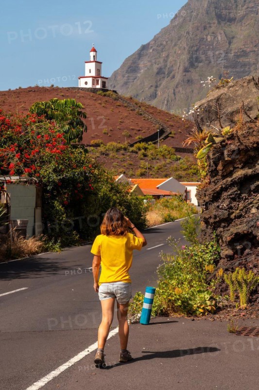 Woman tourist visiting the Joapira bell tower above the parish church of Nuestra Senora de Candelaria in La Frontera on El Hierro