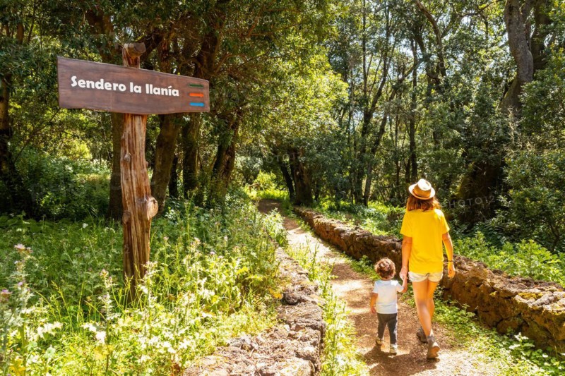 A mother with her son next to a sign identifying the La Llania trekking trail in El Hierro