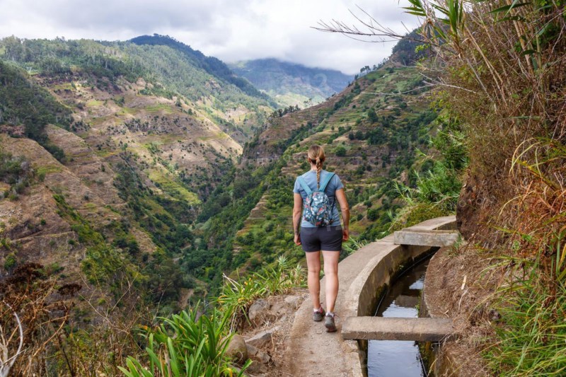 Young woman hiking along the Levada Nova hiking trail on Madeira Island