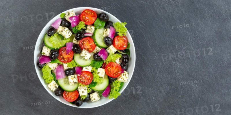Greek salad with fresh tomatoes olives and feta cheese healthy eating food from above on slate banner with text free space in Stuttgart