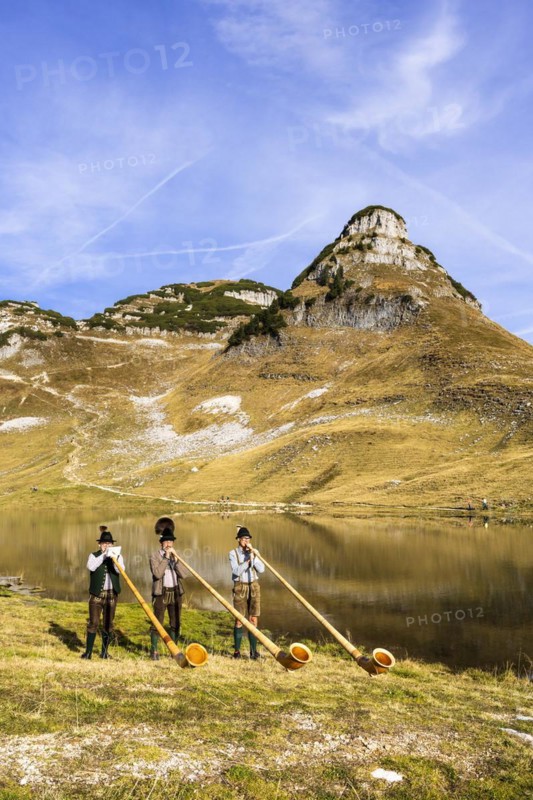 The Austrian alphorn trio Klangholz plays the alphorn at the Augstsee on Mount Loser