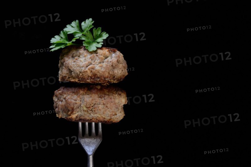 Two homemade meatballs on fork