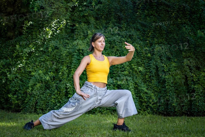 Woman practicing tai chi outdoors. Woman combines the practice of Chi Kung and Chinese martial arts in a natural setting to enhance his practice and his connection to the energy of nature
