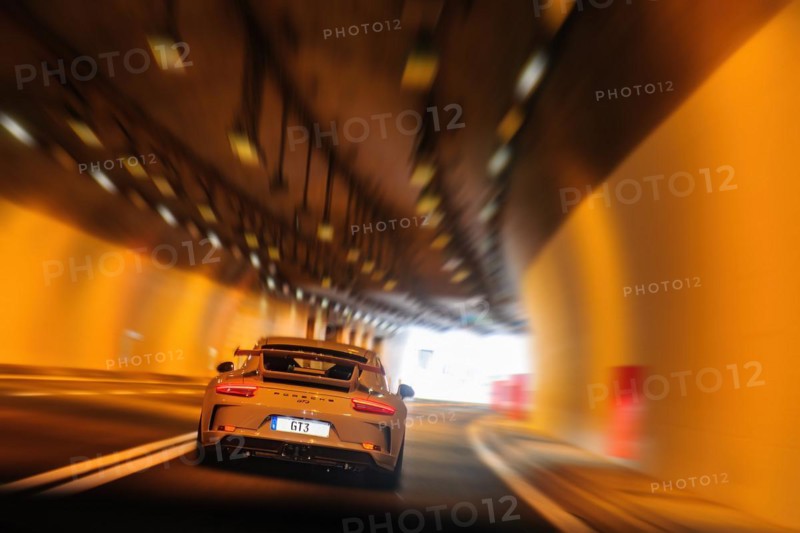 Sports car High-horsepower Porsche 911 GT3 speeder drives slowly fast speeds through road tunnel Tunnel