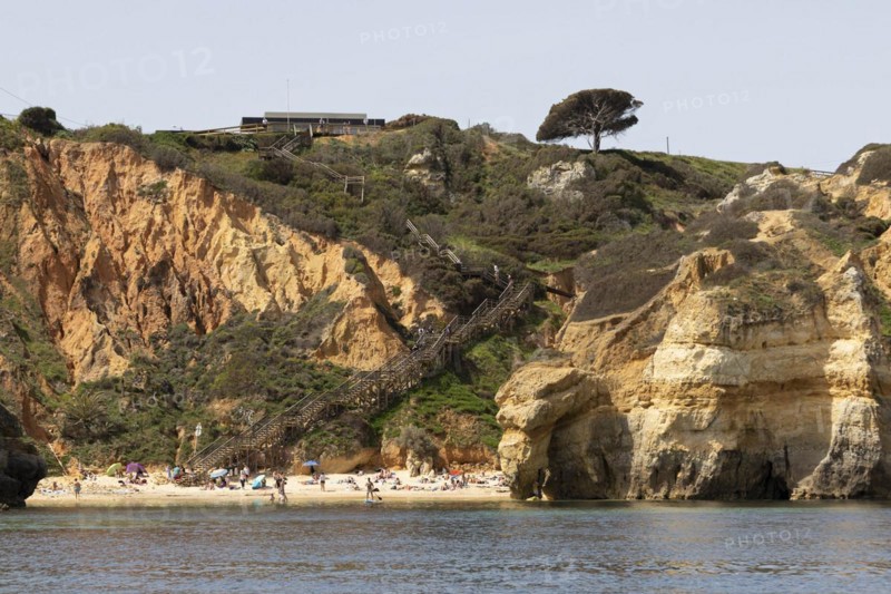 Wooden steps leading to the sandy beach of Praia do Camilo on the rocky coast of Lagos